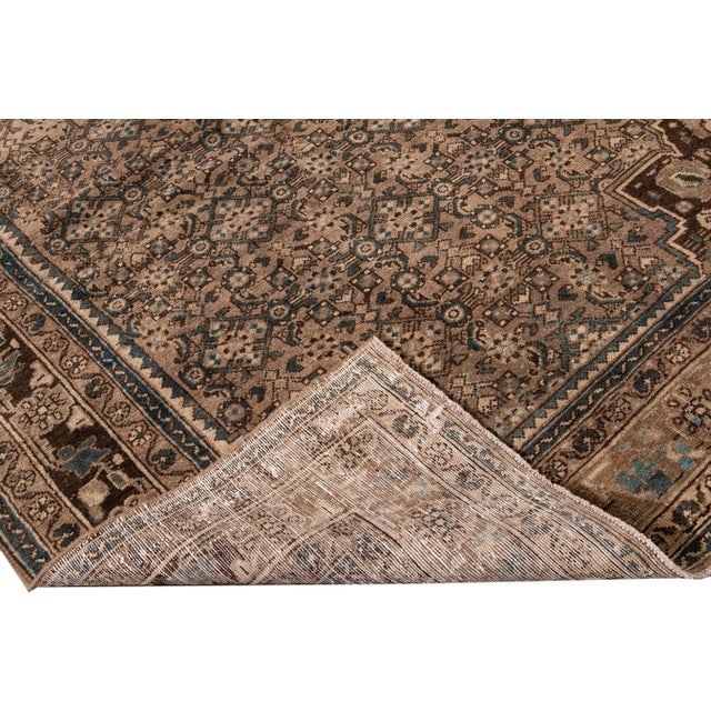 Beautiful vintage Persian distressed hand-knotted wool runner with a brown field. This rug has a brown frame with blue and...