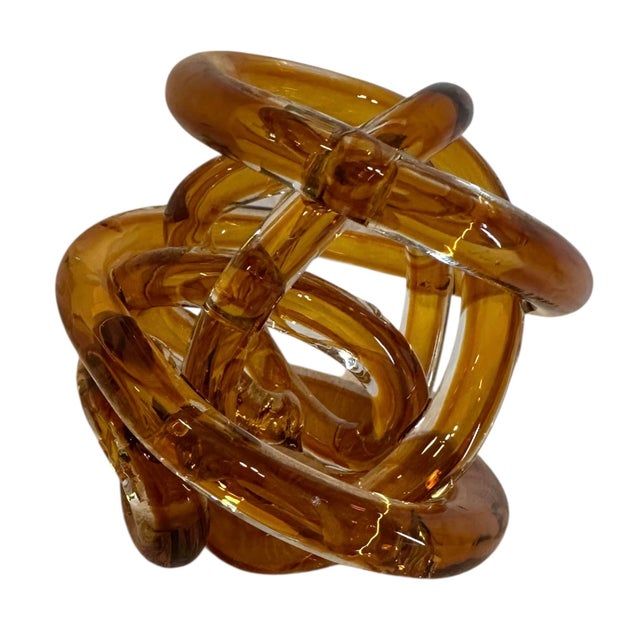 Vintage Amber Glass Knot Sculpture. Radiating with rich amber tones, this sculptural piece adds a sense of comfort and...