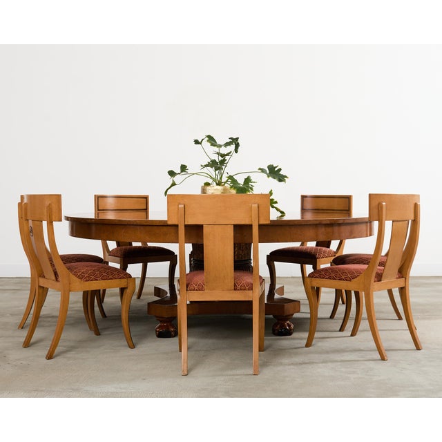 Dramatic set of eight klismos dining chairs constructed in the Greco-Roman neoclassical taste. The chairs feature a tablet...