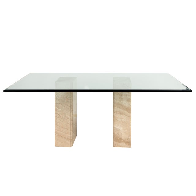 A rare opportunity to acquire a matched suite of Italian postmodern Travertine and glass tables — a double-pedestal dining...
