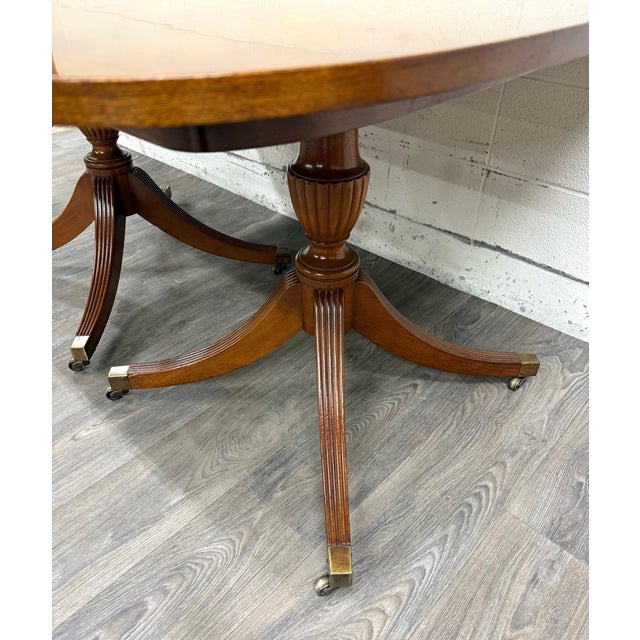 This is a stunning vintage Georgian or Regency Revival, double pedestal dining table crafted in richly figured mahogany....