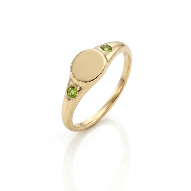 Embrace nature-inspired luxury with this understated signet ring. A clean, unadorned oval plate takes center stage, framed...