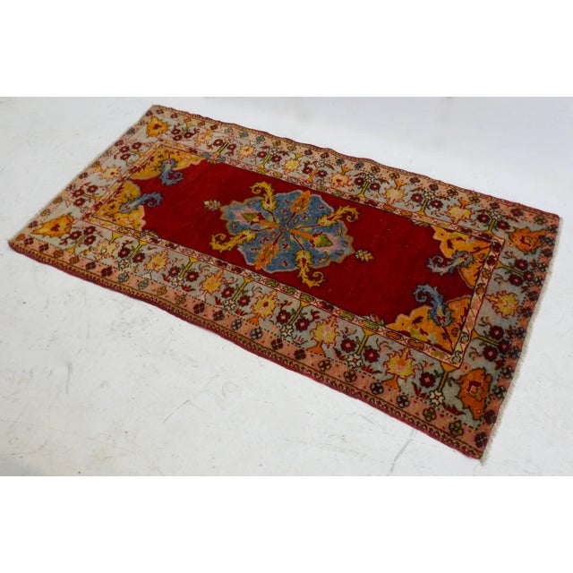 A brightly colored antique Turkish Oushak rug. The hand-knotted rug is made of wool with a geometric design featuring a...