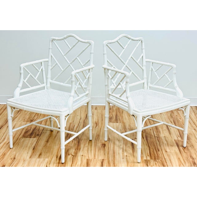 High-quality, vintage warm white Chinese Chippendale armchairs with carved wood and caned seats. High quality pair of...