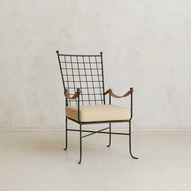 An Italian armchair and ottoman from the 1950s, crafted in wrought iron. The chairs high back unfolds in a rectilinear...