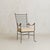 An Italian armchair and ottoman from the 1950s, crafted in wrought iron. The chairs high back unfolds in a rectilinear...