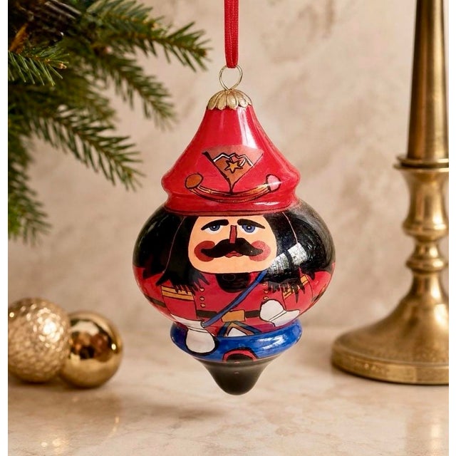 Add a unique touch to your Christmas decor with this beautiful Pier 1 Li Bien "Nutcracker" ornament. This beautiful glass...