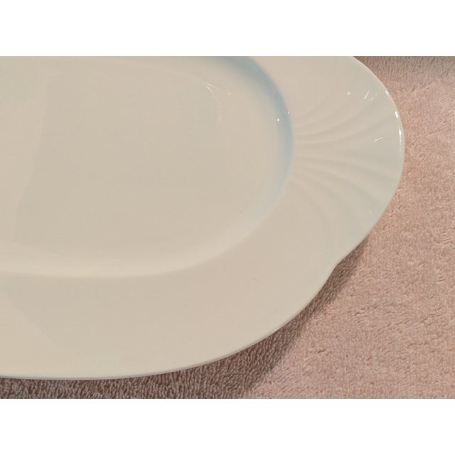 A like-new 13.5-inch platter by Villeroy & Boch in the "Arco Weiss" pattern of an embossed fan design, and a glossy white...