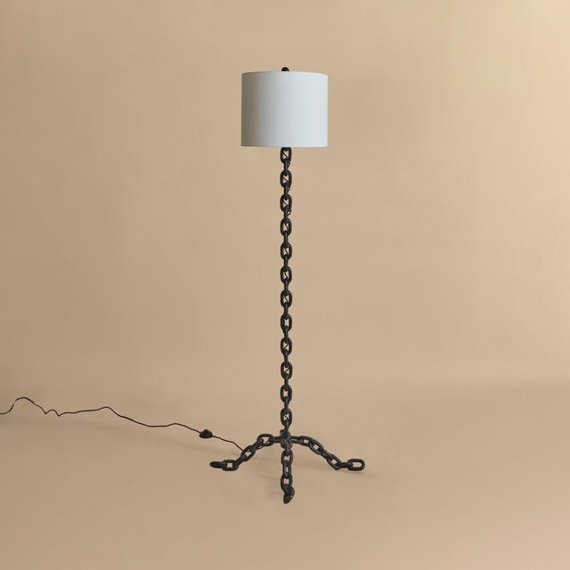 A French iron chain floor lamp from the 1960s. The vertical form is composed of linked iron elements, rising from a three-...