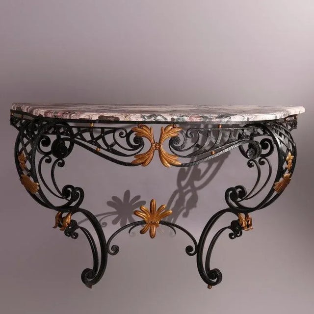 A French Louis XV style console table offers shaped and beveled marble top over basket weave wrought iron base having...