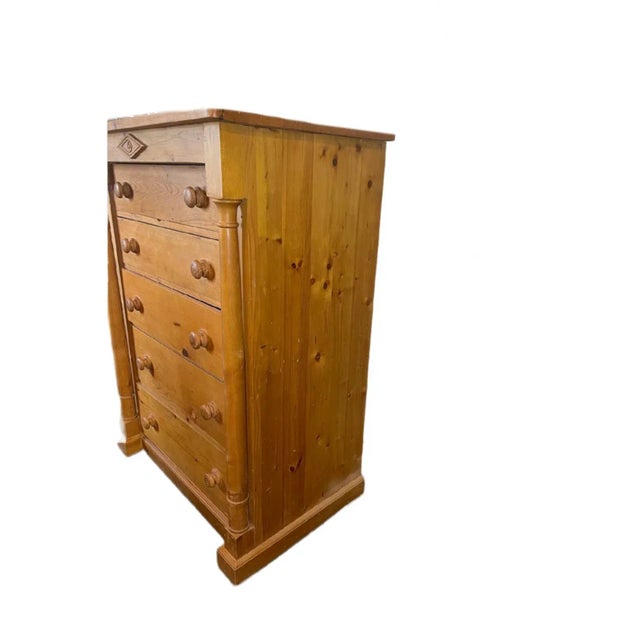Tall pine chest that contains 5 drawers. A transitional piece from the years 2000-2009.