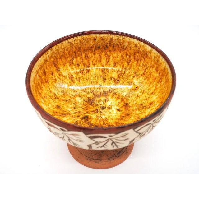 A beautiful and rare vintage nordic design pottery fruitbowl. Lovely decorated with big white leafs on the outside, and...