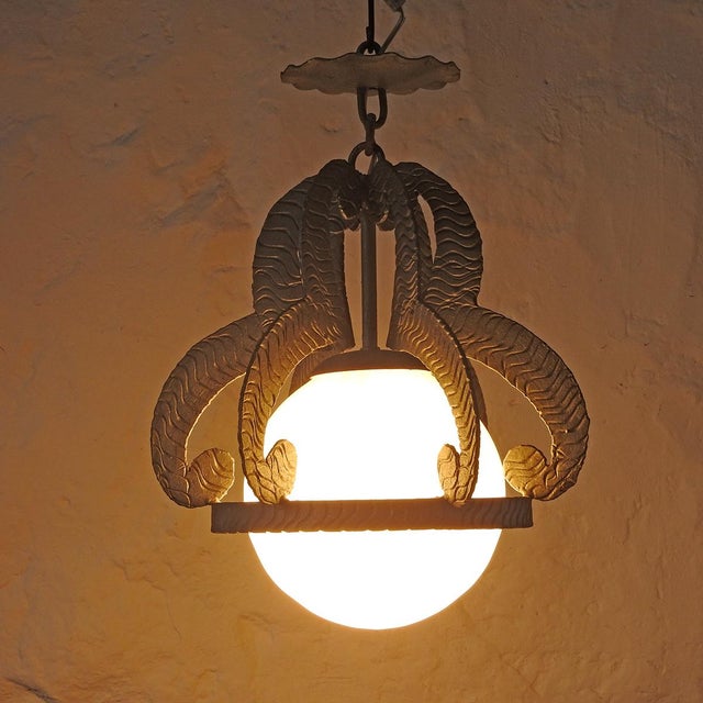 Silver-plated wrought iron, several organically shaped pieces with relief rest on a ring surrounding a blown opaline glass...