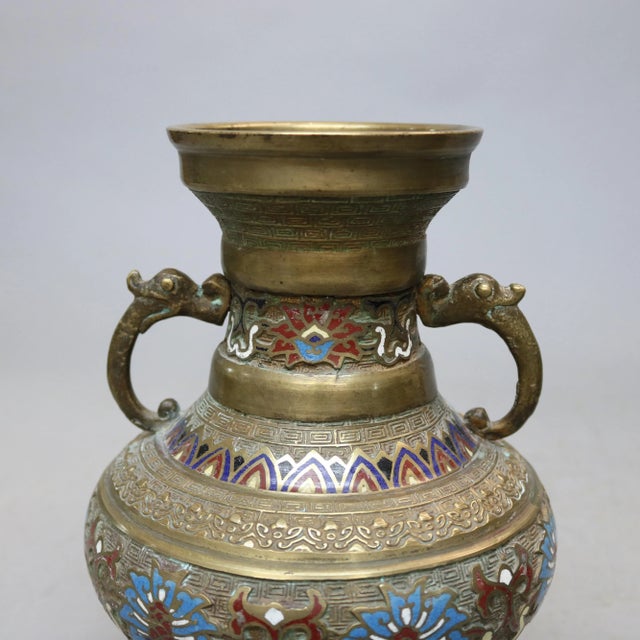 An antique Japanese Persian style vase set offers Champlevé enameled bronze urn form vessels with figural double handles,...