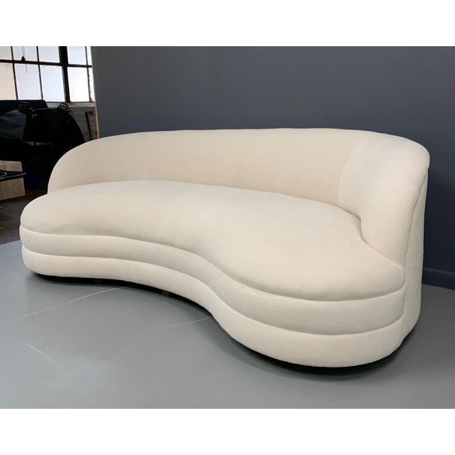 A kidney-shaped sofa that features a nice sculptural modern design, with a curved arched back. These sofas are newly...