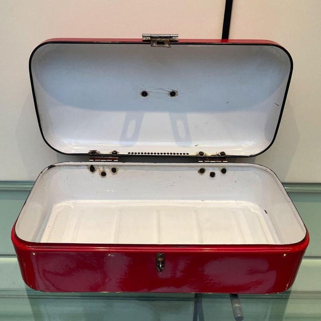 Vintage red enameled steel bread box from the 1950s, originating from the Netherlands. This charming box has a white...