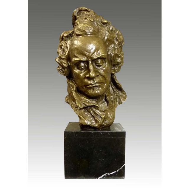 This bronze bust portrays Beethoven with a focused expression and modeled curls, set on a dark marble base. This is a...