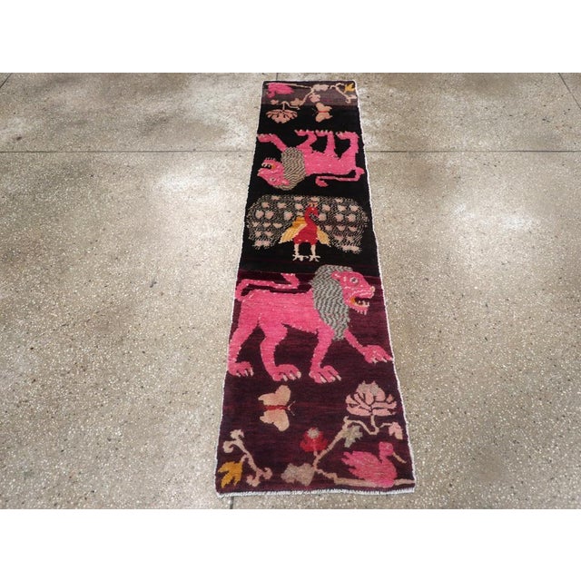 This mid-20th century Tibetan pictorial runner, measuring 1' 7" x 6' 5", bursts with expressive imagery and vibrant color....