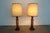 These vintage table lamps date to the mid-20th century and feature sculptural dark-stained wood bases with woven rattan...