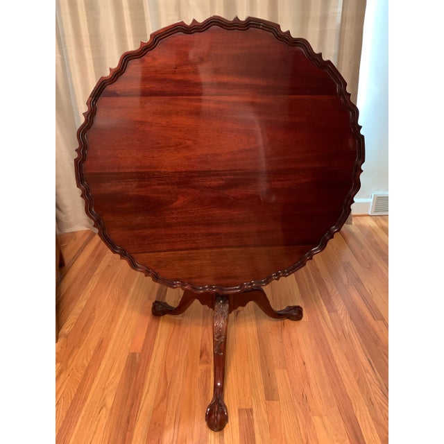 Beautiful reproduction mahogany Chippendale-style pie-crust, tilt-top tea table. Manufactured by Sutton Fine Furniture in...