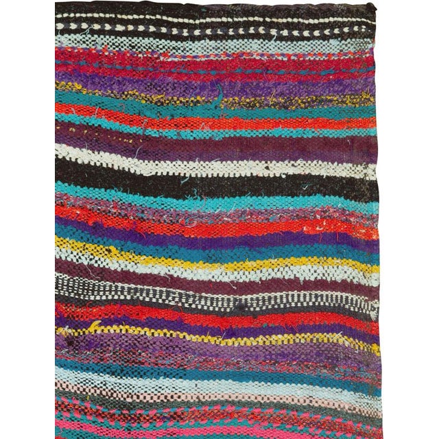 This mid-20th century Persian flatweave kilim rug is a vibrant celebration of color and movement, woven in the traditional...
