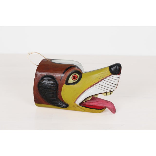 Vintage hand-carved wood mask in the form of a stylized dog or coyote, carved from a single hollowed log section in the...
