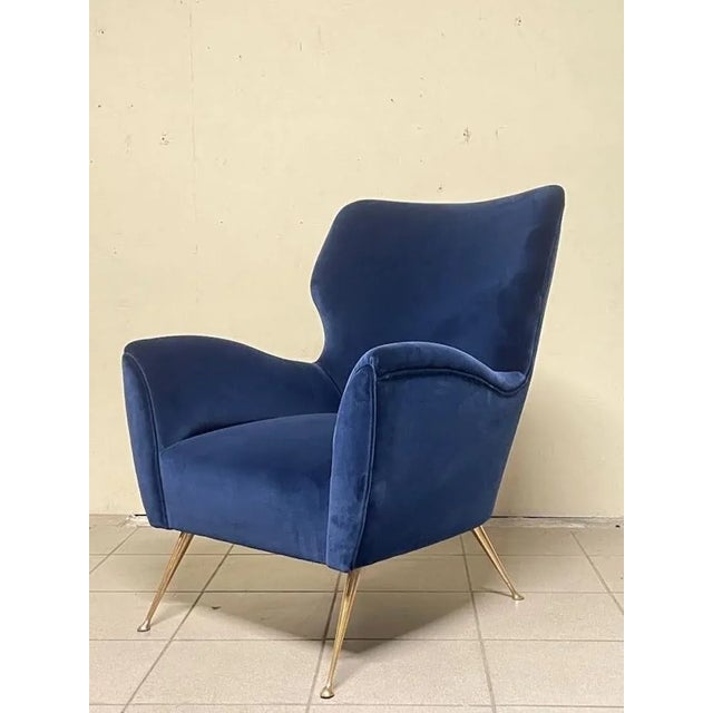 An elegant 1950s blue velvet bergère armchair. Brass legs and fully restored. Very comfortable and compact, it's ideal for...