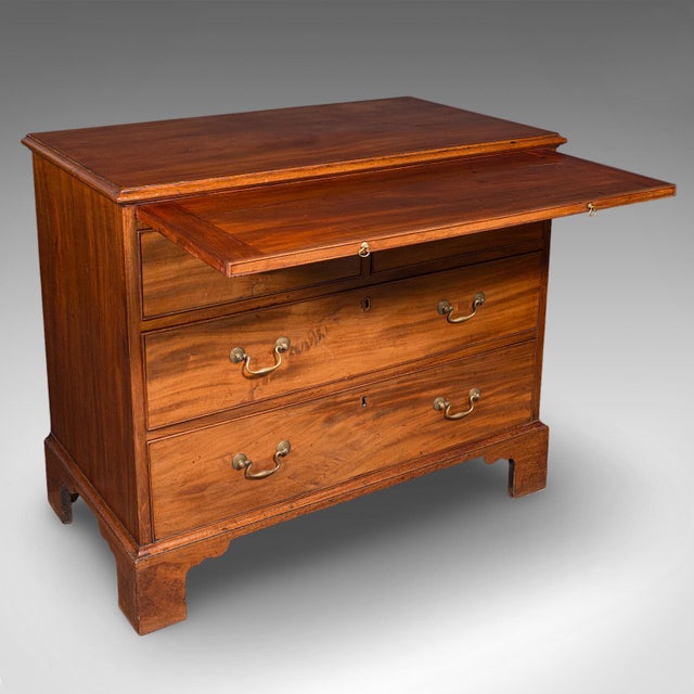 This is an antique bachelor's chest of drawers. An English, mahogany master bedroom tallboy dating to the Georgian period,...