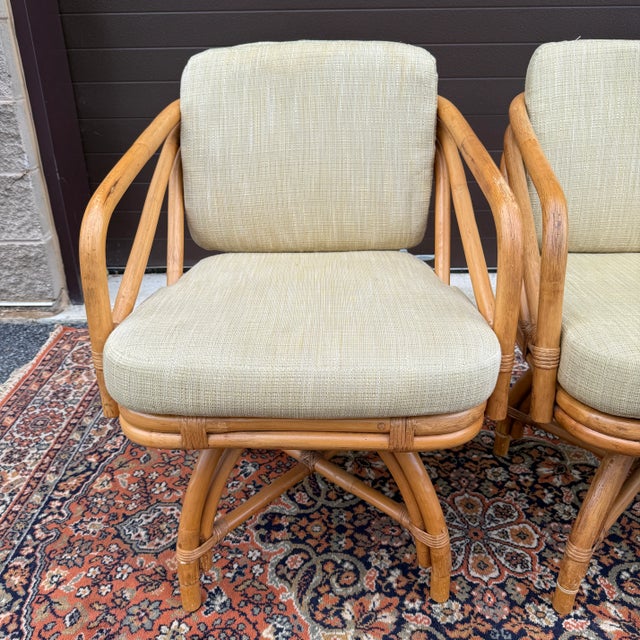 A set of four 20th century Ficks Reed bent rattan swivel chairs with light yellowish green cushions. American made. Circa...