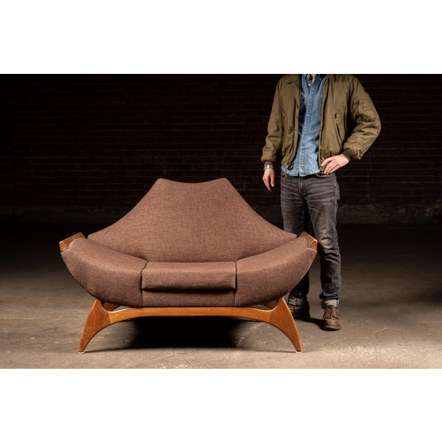 Low-slung gondola-form lounge chair designed after Luigi Tiengo, a Montreal-based furniture designer recognized as an...