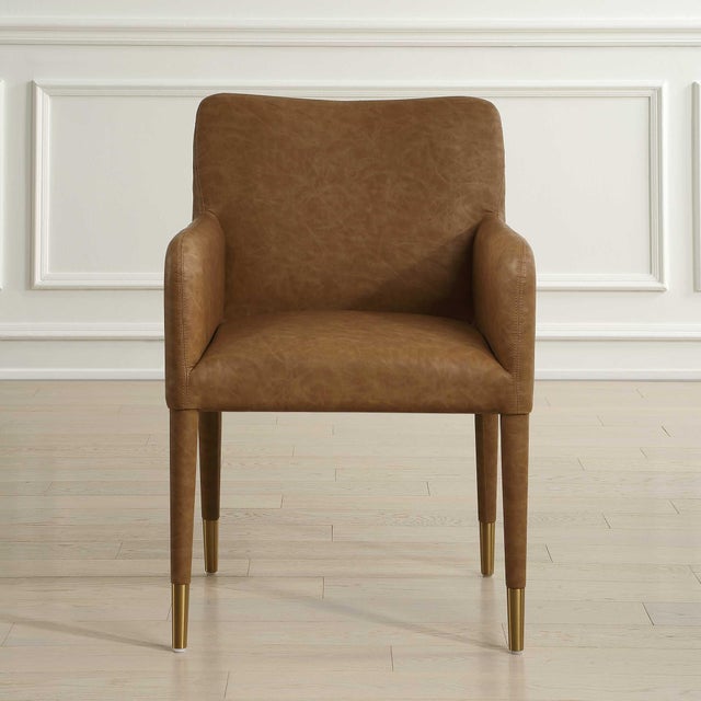 Perfect For Modern Dining, This Armchair Features Sleek Lines Covered In A Rich Camel Faux Leather Accented With Brushed...