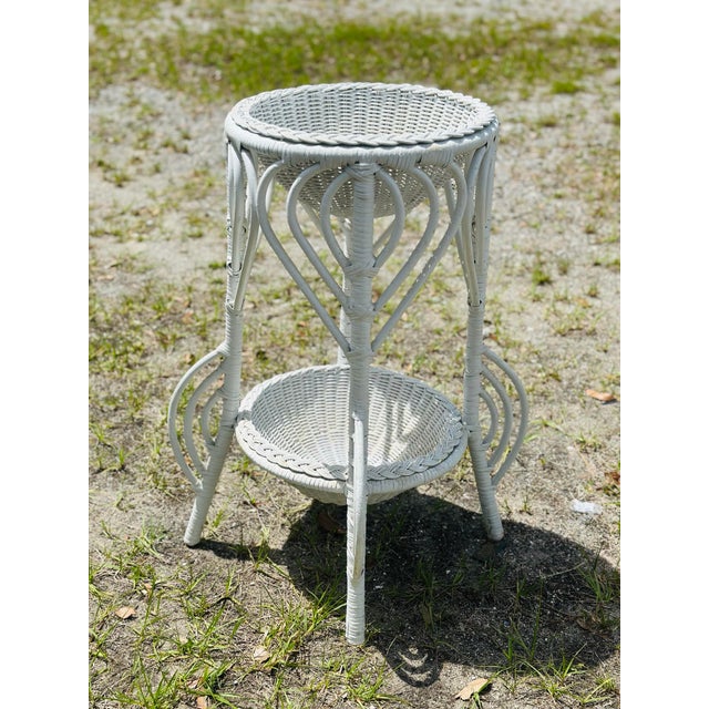 Graceful lines and crisp white wicker, this is a lovely way to display your plants!