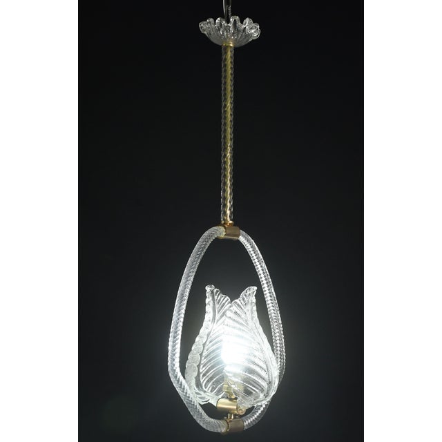 Charming Murano chandelier by artist Ercole Barovier. The pendant consists of 6 glass elements and a brass structure. It...