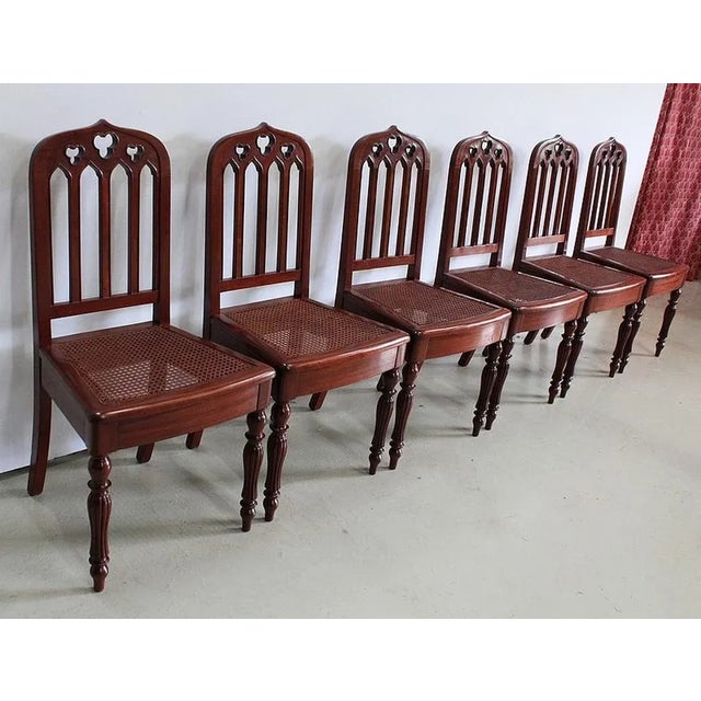 Suite of 6 Mahogany Chairs with Cathedral Backs and Cane Seat, bearing the "Mouchère" mark. Each chair is composed of a...