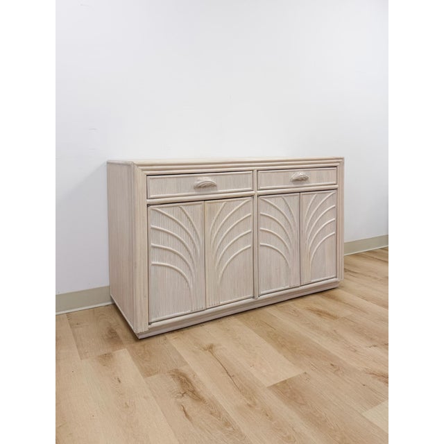 This vintage sideboard showcases pencil reed rattan detailing across a light, blonde-washed finish, capturing the airy,...