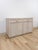 This vintage sideboard showcases pencil reed rattan detailing across a light, blonde-washed finish, capturing the airy,...