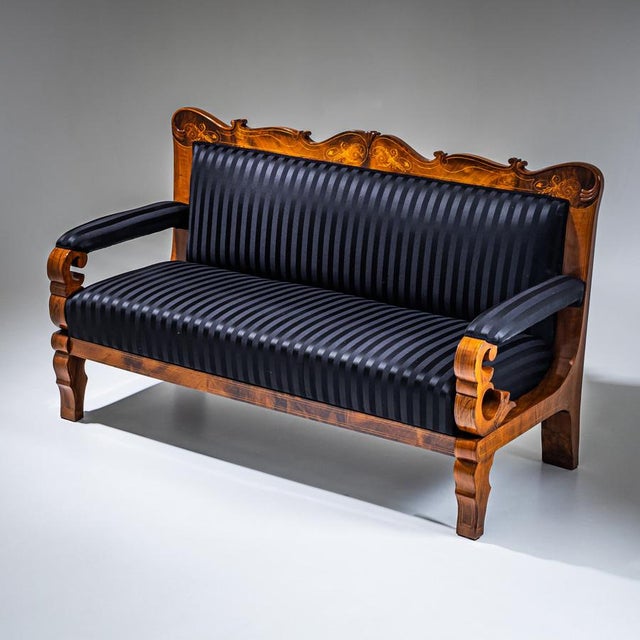 Biedermeier settee veneered in mahogany and accented with fine string inlay along the frame. The multi-curved backrest is...