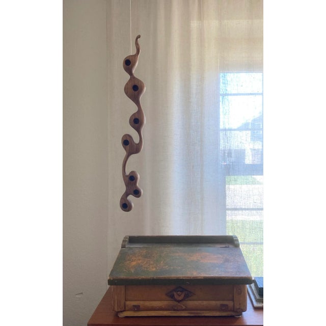 One of a kind, artisan-crafted carved walnut wood sculpture in serpentine form. This can lay flat on a table surface or be...