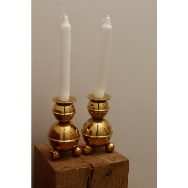 Made in Sweden. A pair of Swedish brass candle holders shaped like spheres and resting on three balled feet. These candle...