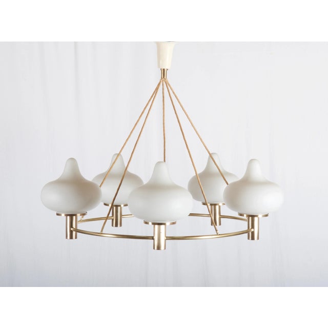 This piece has brass construction fitted with five E27 sockets and matte opaline glass shades. It was designed in Denmark...