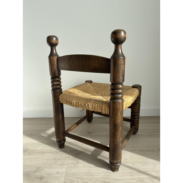 Stunning vintage low chair in solid wood with a woven straw seat. Its thick, turned legs, robust proportions, and...