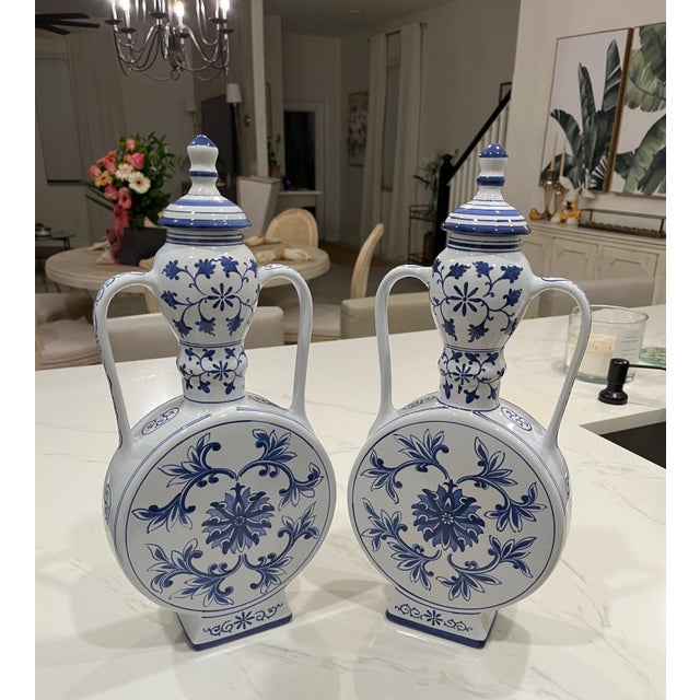 These are a vintage Pair of blue and white Chinese moonflasks from the mid 20th century. Inspired by the Ming Dynasty's...