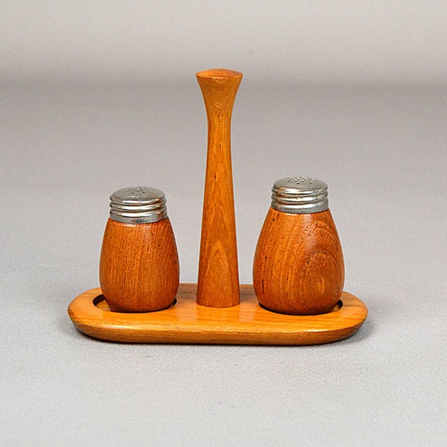 Karl Holmberg's Teak Salt and Pepper Rack in Götene. Two teak spice jars with signed metal lids sit on a rack with a...