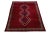 Vintage Shiraz wool rug has a red field and blue accents in a center tribal motif. This rug measure 6'5" x 9'5".