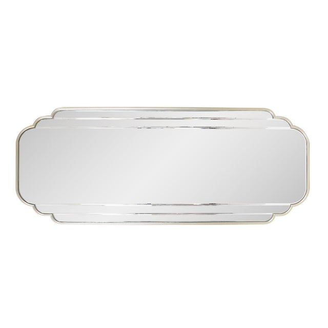The Winton Dressing Mirror features scalloped edges framed in a champagne silver finish and has a beveled design on the...