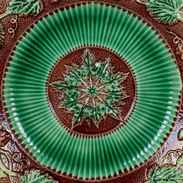 A 19th century English George Jones Majolica glazed ceramic plate with grapevine pattern in green and brown, center...