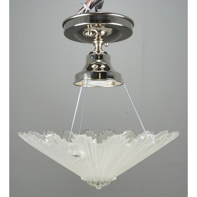 Art Deco semi flush mount made of a clear starburst shaped shade with a chrome finish brass and steel fitter. This...
