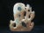 Early 20th-century Chinese hand-carved soapstone foo dog sculpture featuring an intricate double vase and brush washer...
