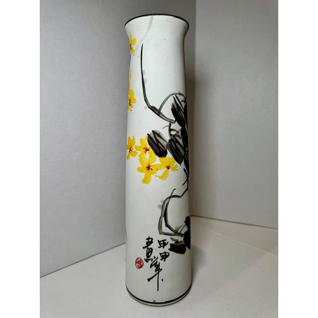 Tall hand-painted porcelain vase decorated with flowering vine motifs in black and yellow enamels. Features calligraphic...