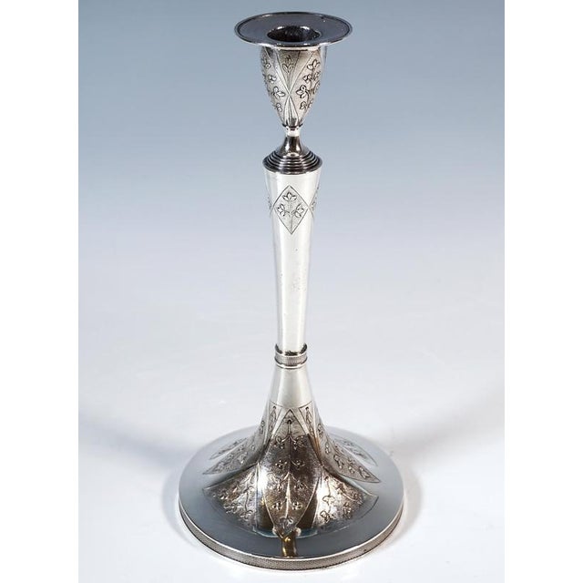 Two elegant silver candlesticks on a round base, guilloché pattern on the side of the base, raised shaft in the centre,...